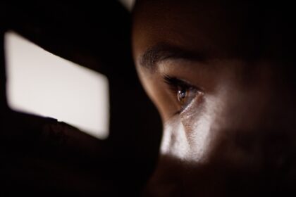 A person spying through a gap of light