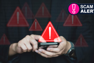 A person holding a phone looking at a scam text with warning signs around