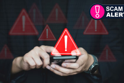 A person holding a phone looking at a scam text with warning signs around
