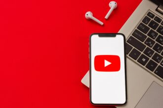 YouTube logo on a phone next to a PC and earbuds