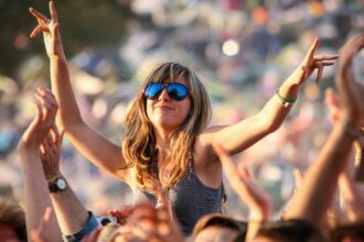 A woman dances on a friend's shoulders at the Glastonbury Festival held at Worthy Farm, in Pilton, Somerset on June 29 near Glastonbury, England. The festival, founded in 1970, has grown into one of the largest outdoor green field festivals in the world.(Photo by Matt Cardy/Getty Images)
