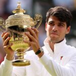 Carlos Alcaraz holds the Wimbledon Men's trophy aloft after his 2024 success.