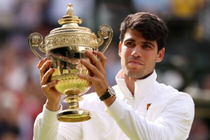Carlos Alcaraz holds the Wimbledon Men's trophy aloft after his 2024 success.