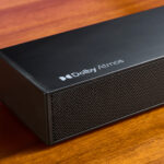 Ultimea Nova S50 soundbar on a wooden surface in front of a TV