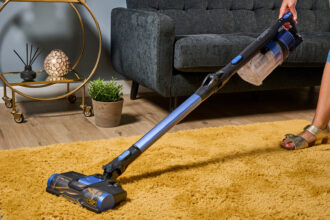 The Shark Anti Hair Wrap Cordless Vacuum cleaning a rug