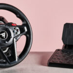 Thrustmaster T128 on desk with pink background