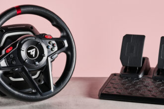 Thrustmaster T128 on desk with pink background