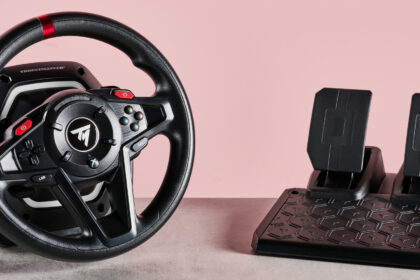 Thrustmaster T128 on desk with pink background