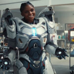 A smiling Riri Williams wearing her white iron armor suit in Ironheart