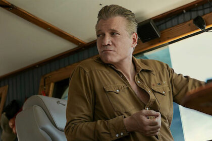 A still from The Waterfront showing Holt McCallany driving a boat