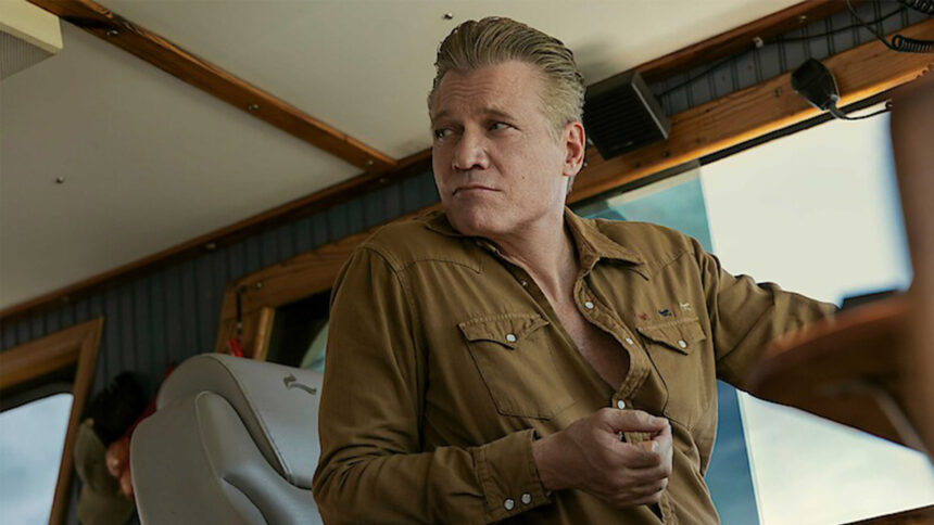 A still from The Waterfront showing Holt McCallany driving a boat