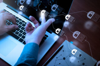 Hands working on laptops touching diagram of chain and encrypted blocks