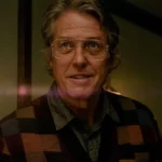 Hugh Grant holds a lit candle in Heretic