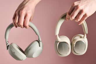 Person holding Sony WH-1000XM6 and Bowers &amp; Wilkins Px7 S3