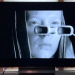LG C4 OLED TV showing image of woman looking through glasses