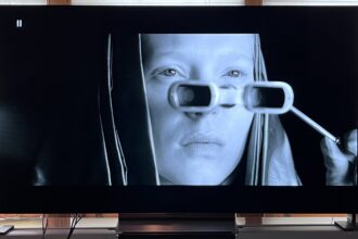 LG C4 OLED TV showing image of woman looking through glasses