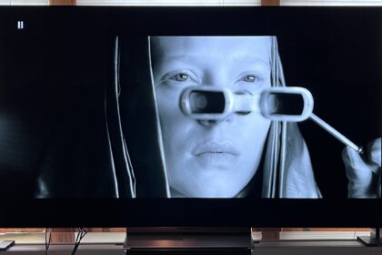 LG C4 OLED TV showing image of woman looking through glasses
