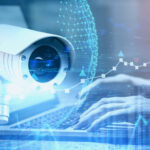 A surveillance camera and someone using a laptop.