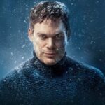 Dexter wears a navy knitted turtleneck jumper, starting straight down the lens covered in snow