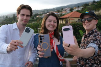 Three people holding the best AI phones - Samsung Galaxy S25 Ultra, iPhone 16 Pro, Google Pixel 9 Pro