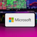 Microsoft logo on mobile phone screen company shares rise or fall on stock exchange market