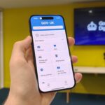 The Gov.uk app open on an iPhone 15 in a brieifing room