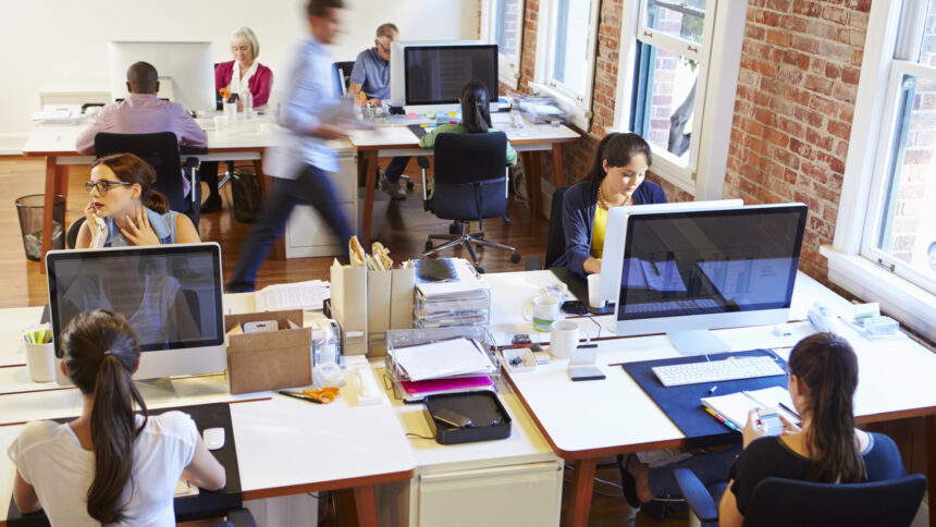 Busy office with iMac computers and people working