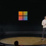 Mustafa at Microsoft 50th Anniversary event in front of Windows logo