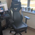 The AutoFull M6 Ultra gaming chair pictured in front of a desk with a gaming PC setup.