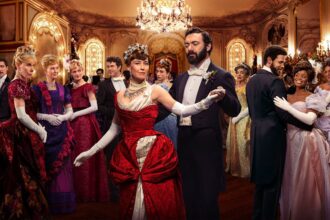 The cast of The Gilded Age look at each other across a ballroom
