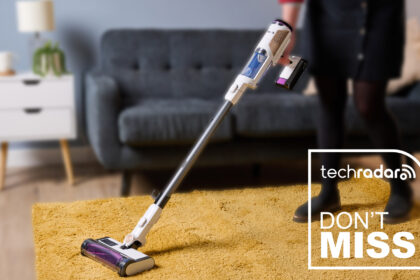 A woman using the Shark Detect Pro Cordless on a yellow rug