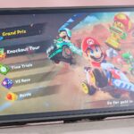 The Nintendo Switch 2 with the Belkin Tempered Glass Anti-Reflective Screen Protector applied; Mario Kart World is displayed on screen with bright, vibrant colors.