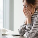 Shocked woman worker looking at laptop screen