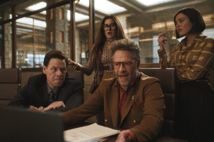 Four TV executives sitting and standing around a table in Apple TV Plus show The Studio