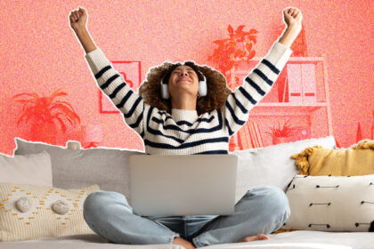 A young woman sitting on a sofa, wearing headphones and throwing her arms excitedly into the air.