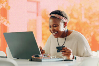 A woman looking happy whilst online shopping on a laptop.