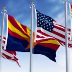 Flags of Arizona and United States waving in the wind on a clear day