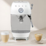 Smeg ECF03 coffee machine on counter with coffee drinks