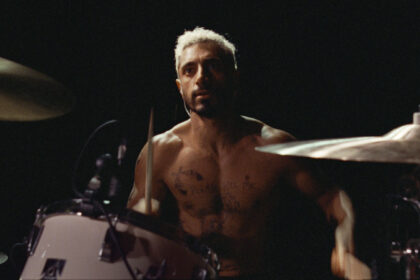 A still from the movie Sound of Metal showing Riz Ahmed's character Ruben playing the drums.