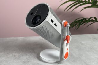 The XGIMI Mogo 4 is pictured on a tabletop, with the lens pointing up and left.