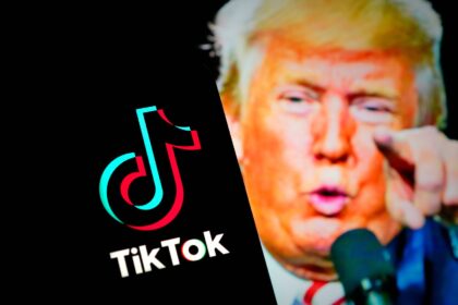 The TikTok logo is seen on a mobile device, with a picture of US President Trump in the background
