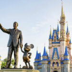 Walt Disney statue in front of Cinderella Castle at Disney World on a sunny day
