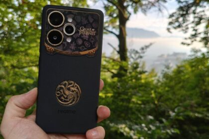The Realme 15 Pro Game of Thrones Edition ahead of a leafy background and a distant fortress.