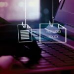 Image depicting hands typing on a keyboard, with phishing hooks holding files, passwords and credit cards.