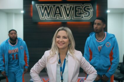 Isla stands in front of two players and the LA Waves sign in Running Point