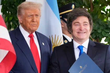 Argentine President Javier Milei and former U.S. President Donald Trump smiling and posing for photographs outside the White House, shaking hands.