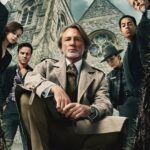 The cast of Wake Up Dead Man look into a grave