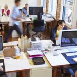 Busy office with iMac computers and people working