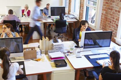 Busy office with iMac computers and people working
