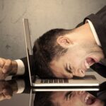 Angry business man screaming on laptop